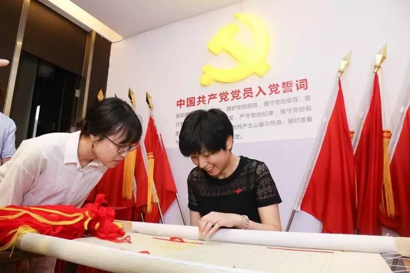 图为施工人员细心描绘滨河步道旁的文化墙。